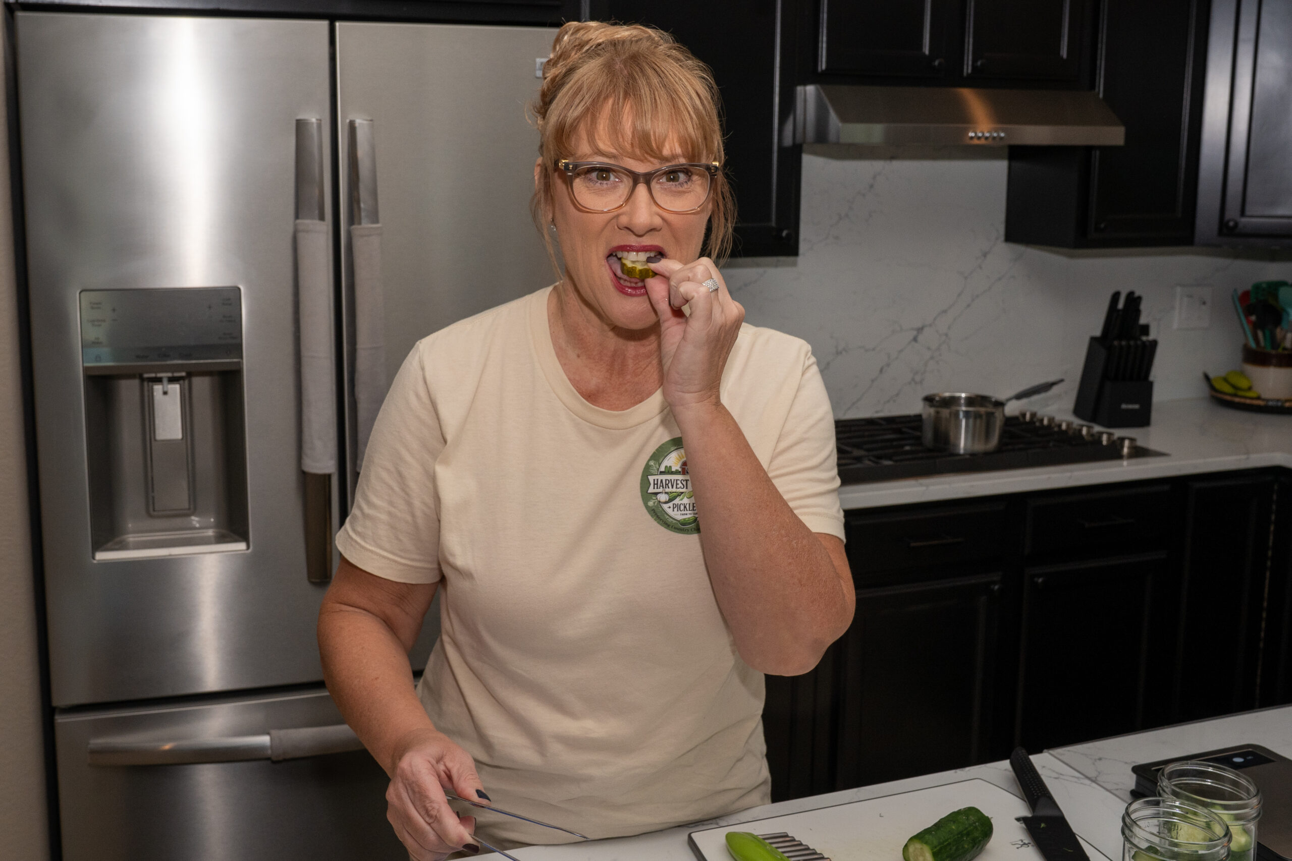 Melissa Whan of Harvest & Brine Pickle Company eats a pickle in her Rancho El Dorado kitchen on July 18, 2025. [David Iversen]
