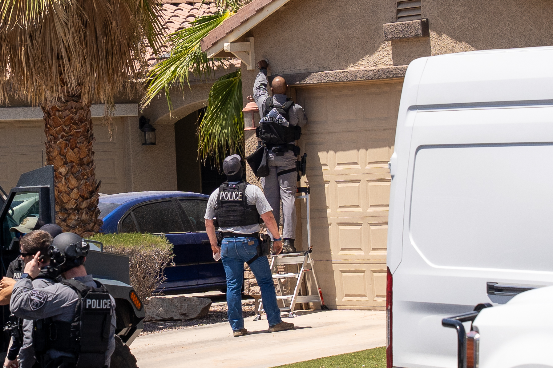 Federal agents in tactical gear storm the front entrance of a Glennwilde home during a Homeland Security operation on Chimayo Drive. Aug. 5, 2025. [David Iversen]