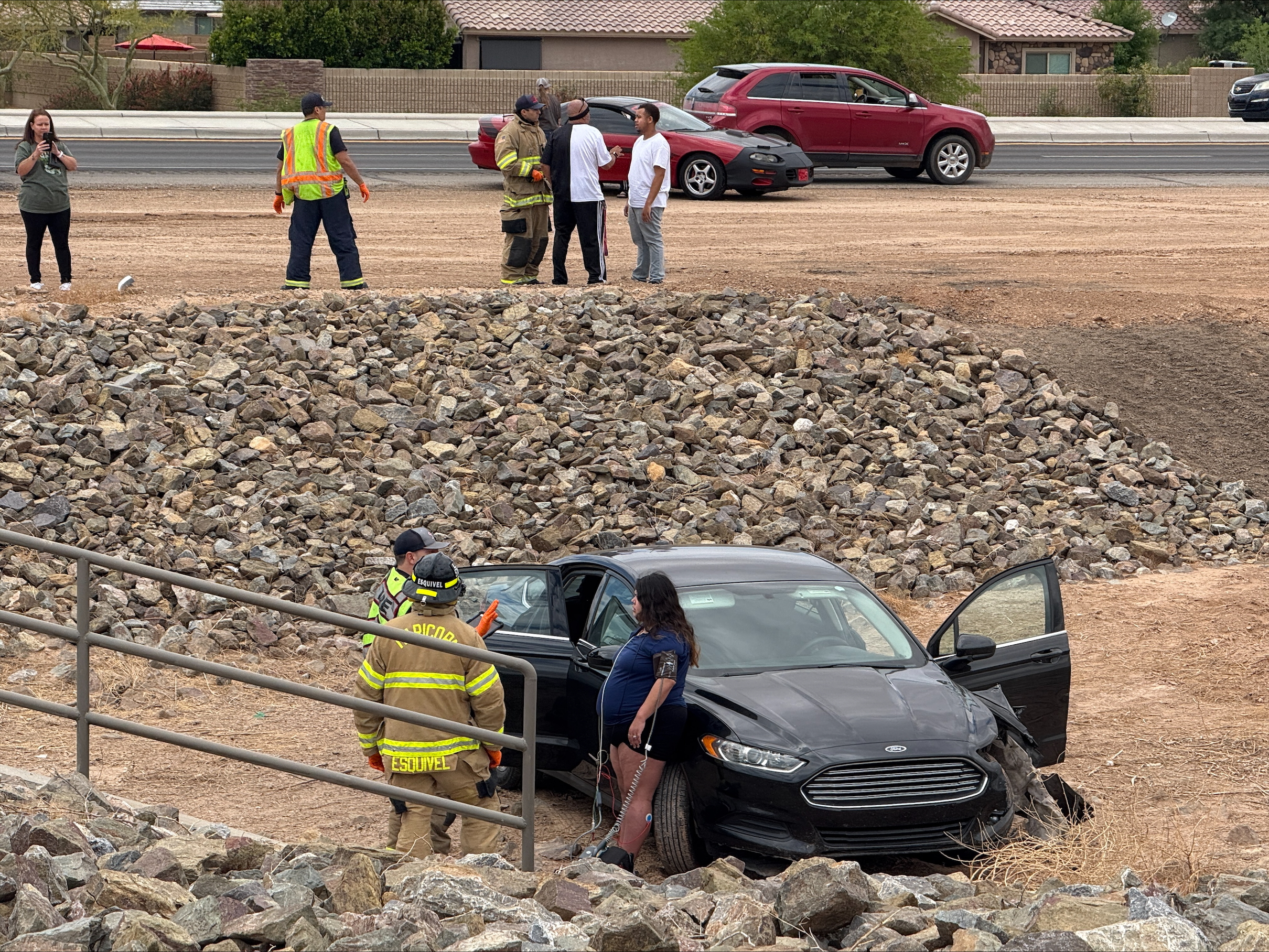 A woman is evaluated by firefighters after her black Ford Fusion crashed into a ditch off John Wayne Parkway. May 6, 2025. [Brian Petersheim Jr.]