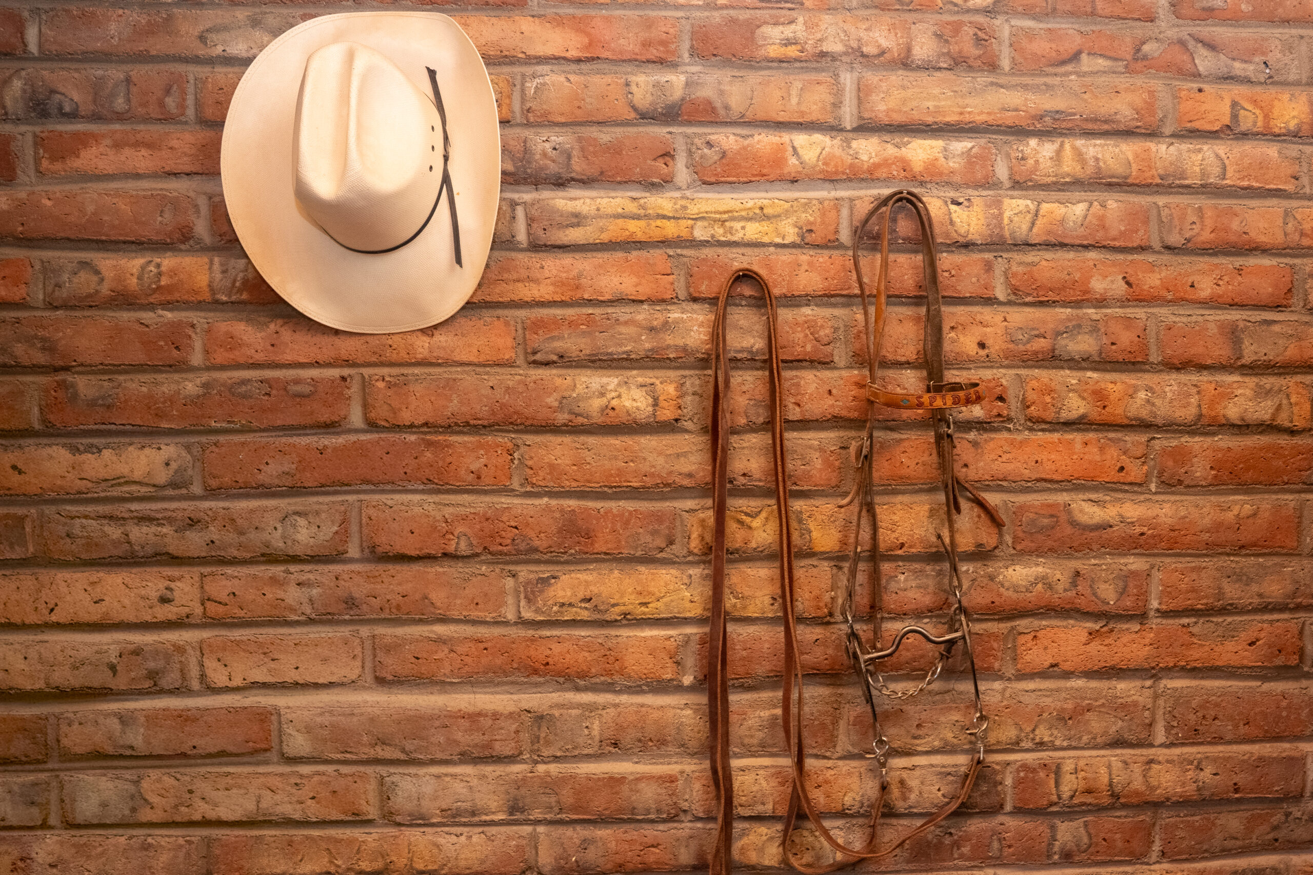 Vintage cowboy equipment hangs on a brick wall inside the Smith House, one of the stops on Maricopa’s $5 history tour, Oct. 22, 2025. [David Iversen]