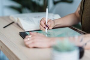 An artist draws on a tablet in this undated photo. [Michael Burrows/Pexels]