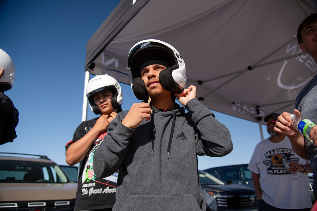 A student puts on a helmet before joining a drifting demonstration at Nissan Technical Center on April 18, 2026. [Monica D. Spencer]