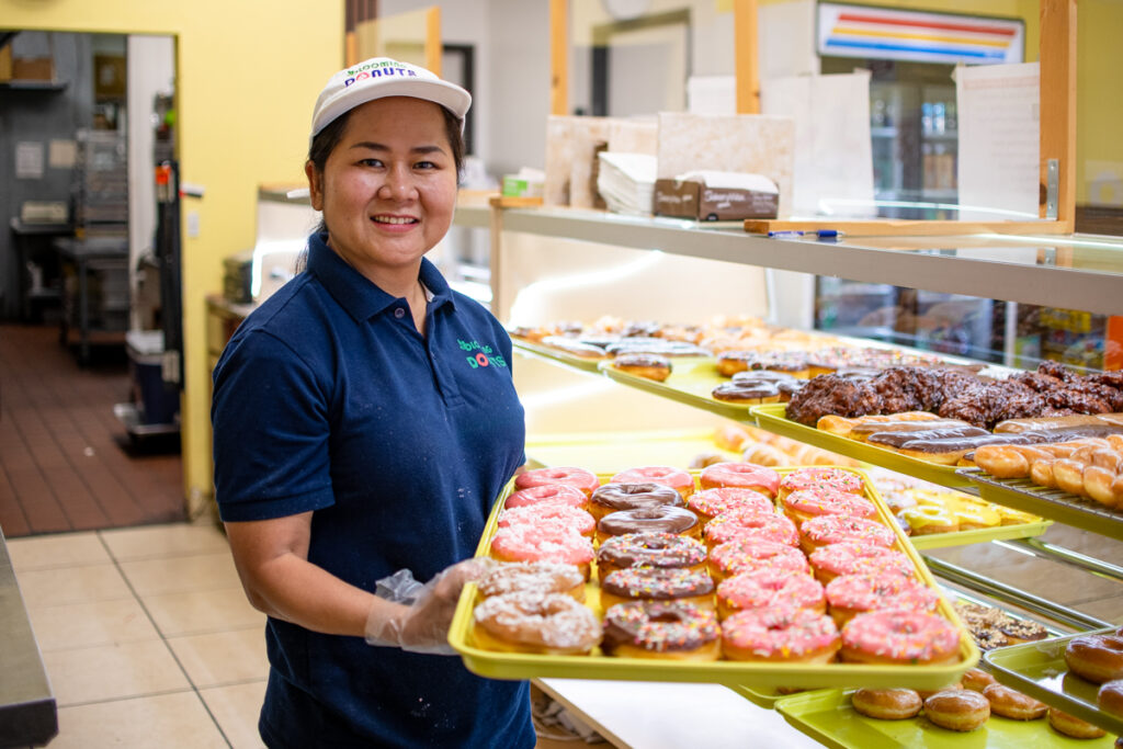 Sokvimom Koa, owner of Blooming Donuts, stands with a tray of donuts on June 6, 2026. [Monica D. Spencer]