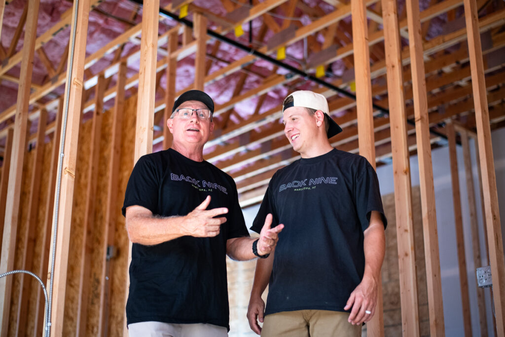 Danny and Parker Hunsaker, co-owners of the upcoming Back Nine indoor golf simulator, stand inside the building under construction on Sept. 22, 2026. [Monica D. Spencer]