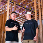 Danny and Parker Hunsaker, co-owners of the upcoming Back Nine indoor golf simulator, stand inside the building under construction on Sept. 22, 2026. [Monica D. Spencer]