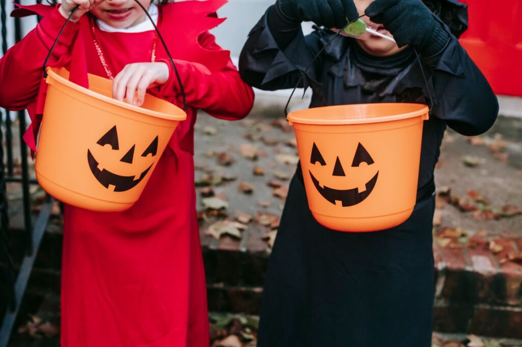 Children look through candy buckets while trick-or-treating. [Charles Parker]