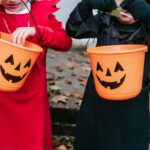 Children look through candy buckets while trick-or-treating. [Charles Parker]