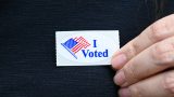 A voter showed off her voting sticker outside Maricopa Community Center on July 21, 2026. [Karen Bartunek]