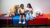 Therapy dog Honey sits with twins Perla and Victoria Ruiz Luna, 8, during a reading session at Maricopa Library and Cultural Center on Sept. 9, 2026. [Monica D. Spencer]