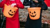Children look through candy buckets while trick-or-treating. [Charles Parker]